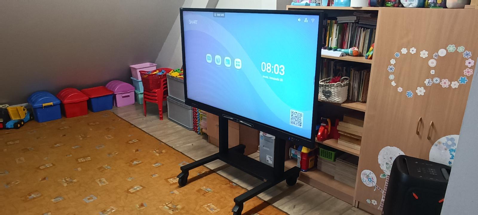 Monitor na mobilnym stojaku w sali przedszkola w Gdyni