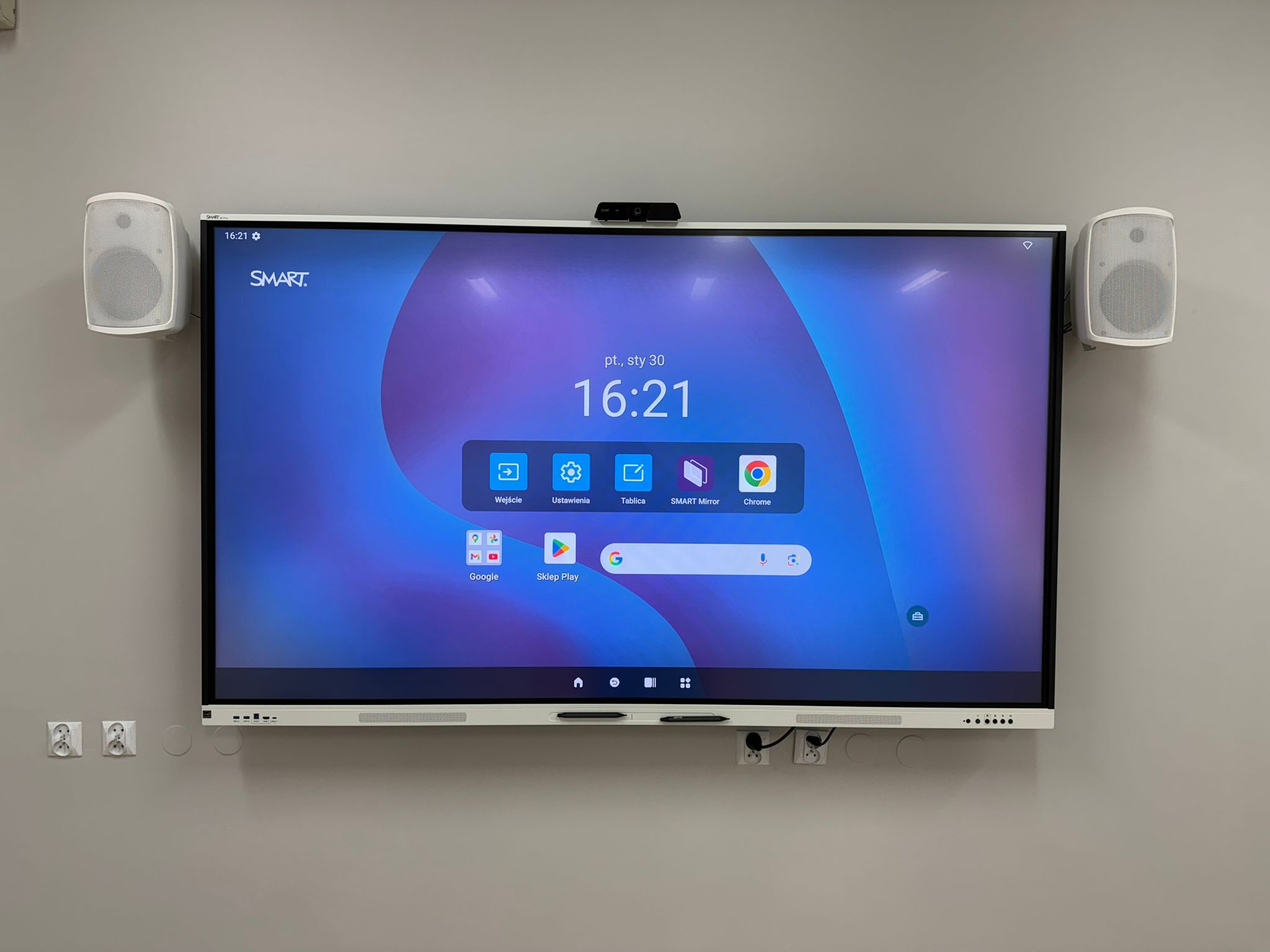 Monitor interaktywny SMART z kamerą i głośnikami na ścianie w szkole podstawowej w Warszawie